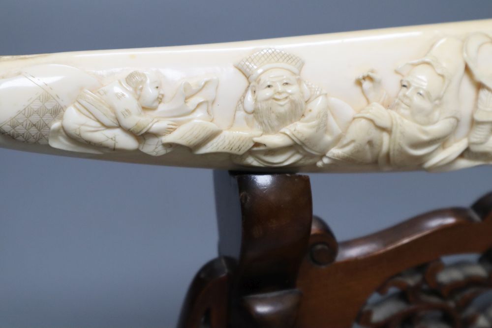 A Japanese ivory Seven immortals tusk carving, early 20th century, wood stand, signed, 44cm excl. stand